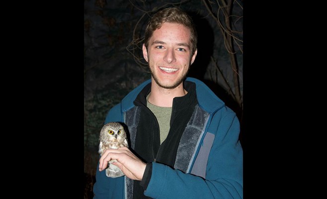 Mitchell Pruitt holding a baby saw whet owl.