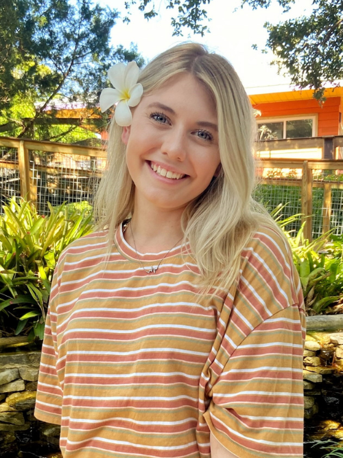 Photo of Alana smiling outdoors with a flower in her hair